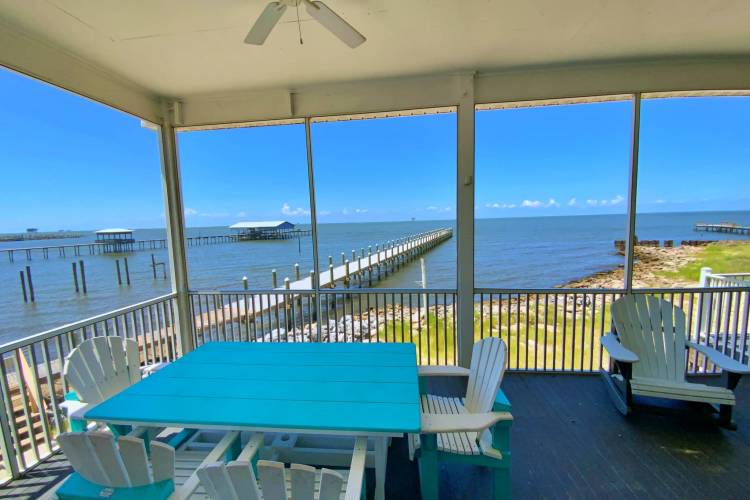 Screened in porch with view of pier and bay